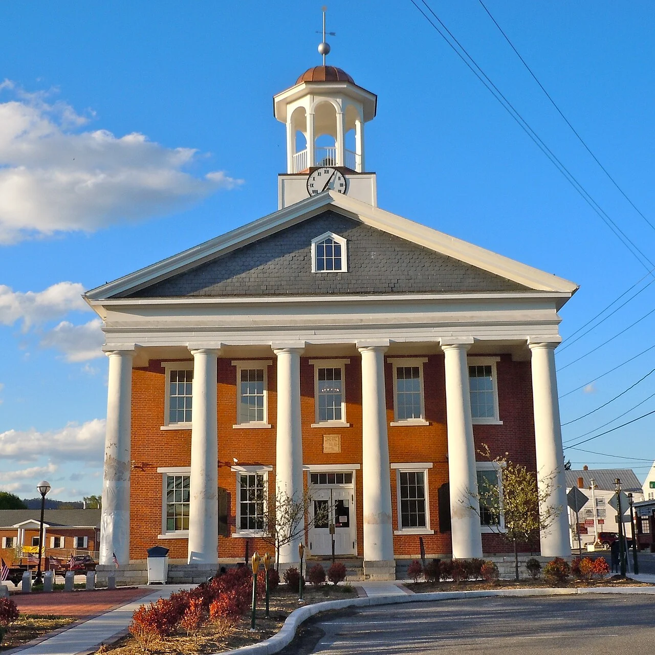 Fulton County Courthouse with white columns and a clock cupola in McConnellsburg, Pennsylvania.